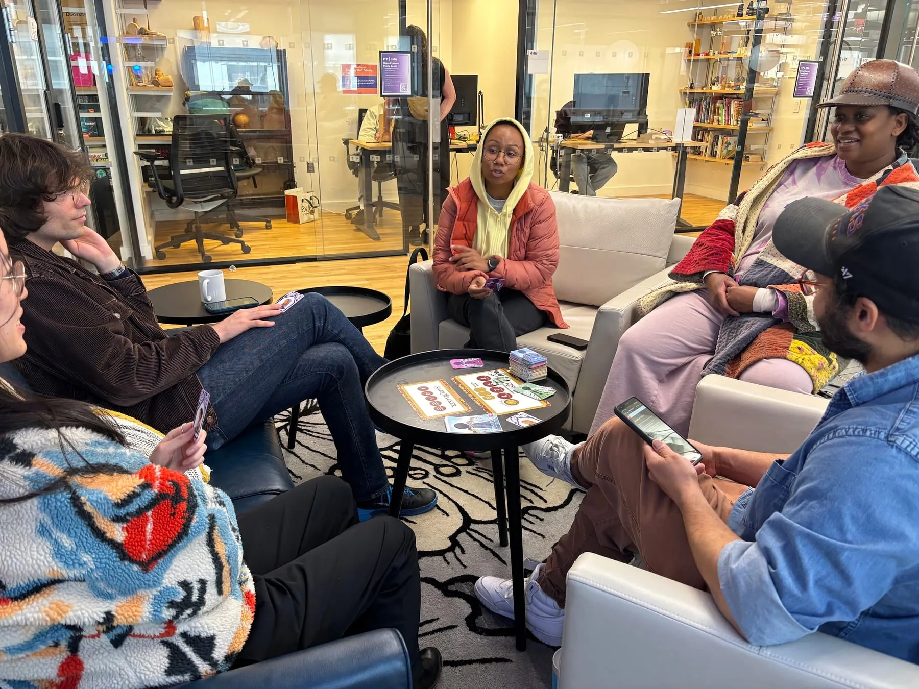 Players spread across armchairs and low tables in an NYU lounge