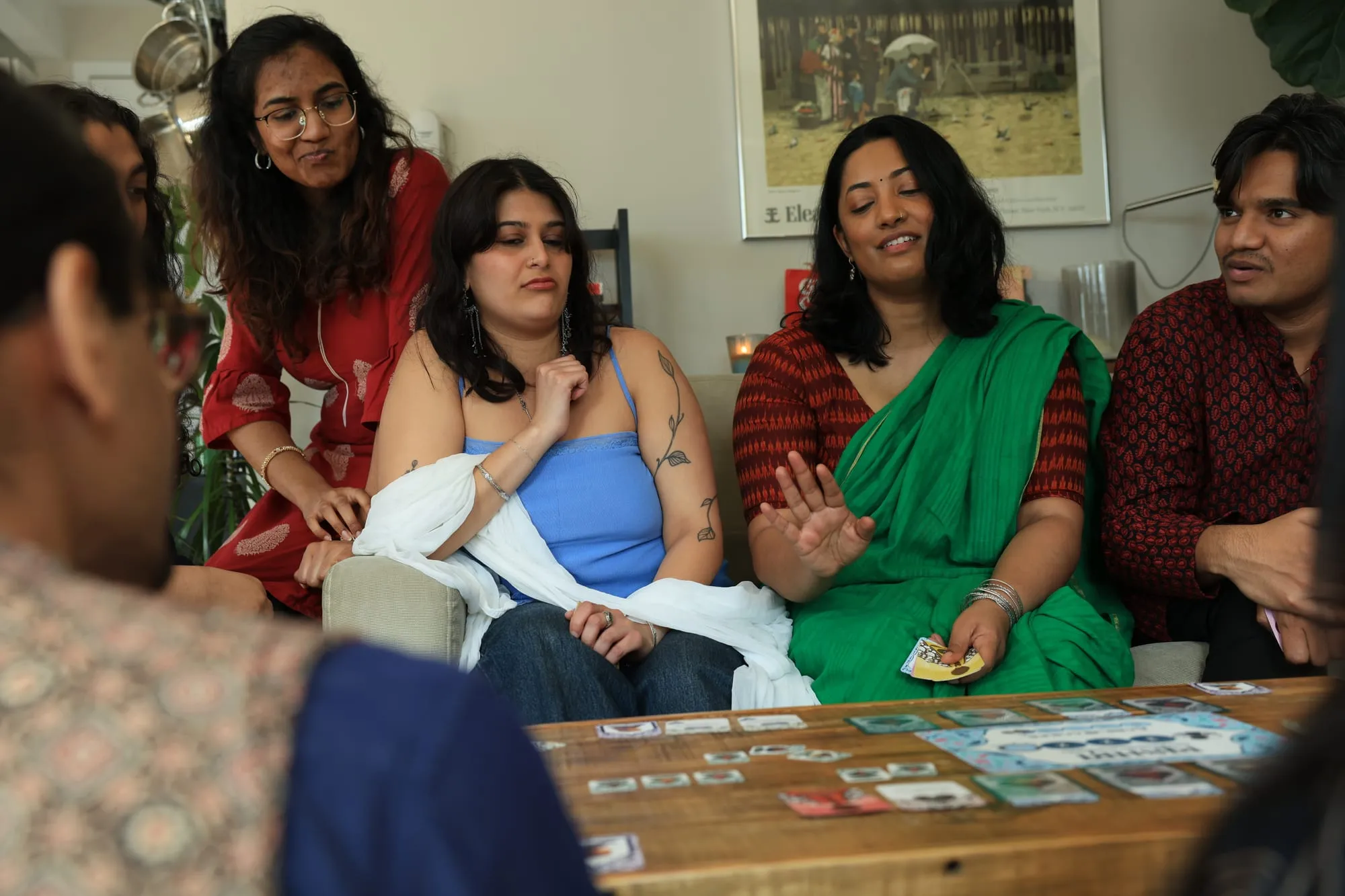 Four players pressed together on a sofa, each holding a hand of cards