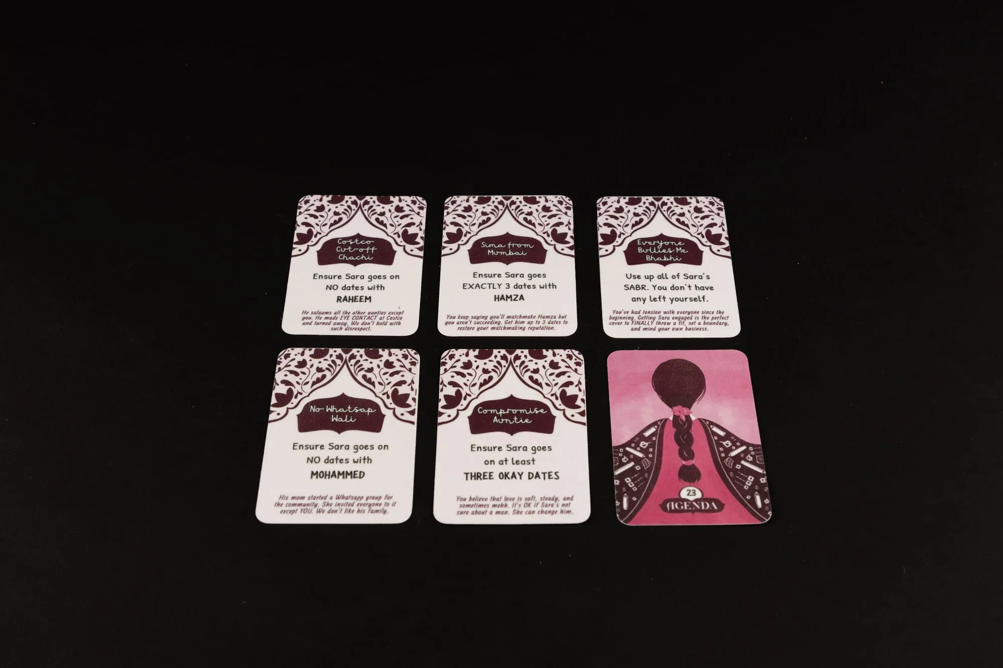 Six agenda cards face up on black, each naming a secret win condition
