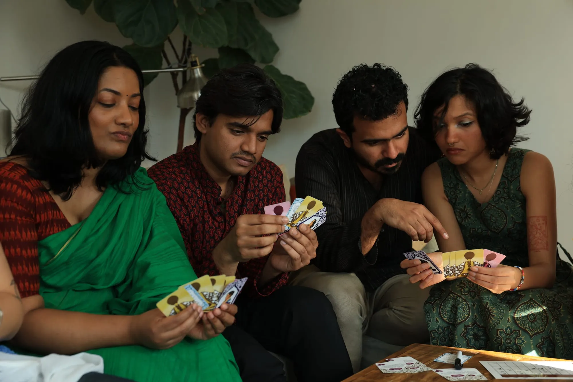 Four players pressed together on a sofa, holding their auntie cards