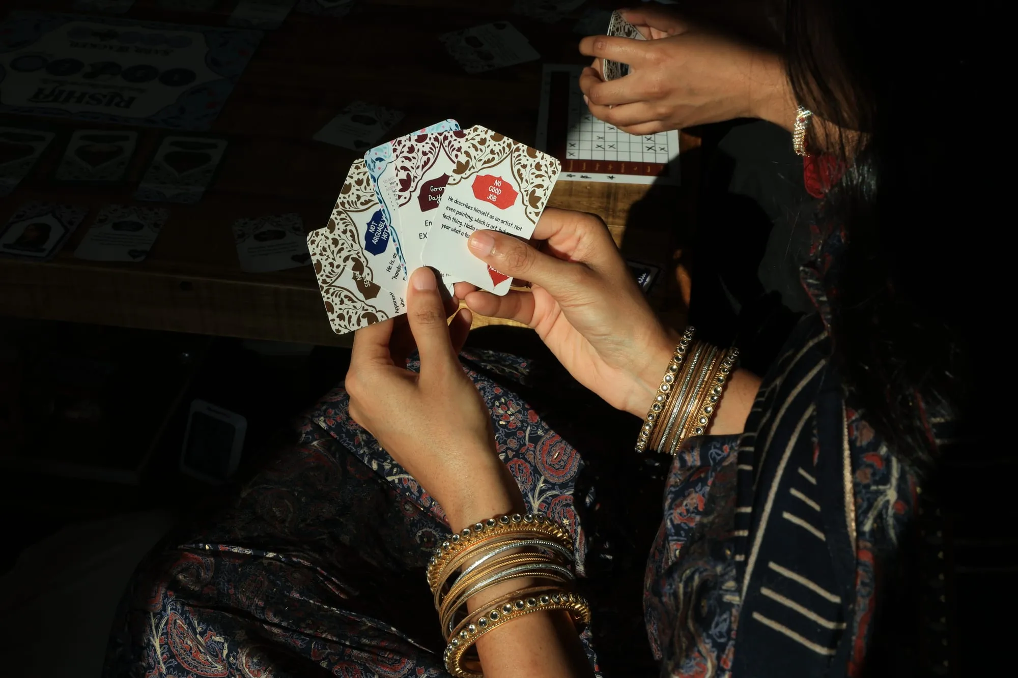 A player studying a hand of gossip cards in low light